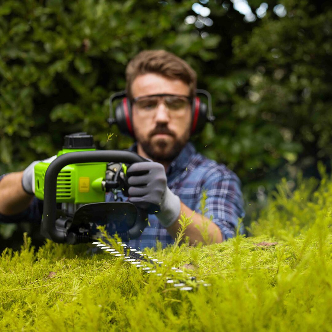 man trimming hedge